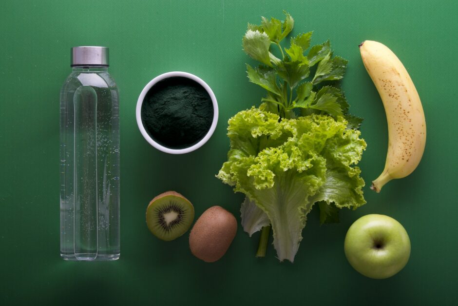 緑の背面に野菜や果物、水が置かれた様子